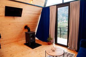 a living room with a wood stove in front of a window at Hill sunny2024 in Zemo Jocho