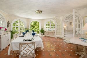comedor con mesa y algunas ventanas en Villa Whitegates, en Saint James