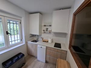eine kleine Küche mit weißen Schränken und einem Fenster in der Unterkunft La Vista de Gredos in Navarredonda de Gredos