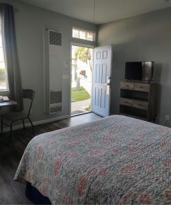 a bedroom with a bed and a door to a yard at Pacific Plaza Resort in Oceano