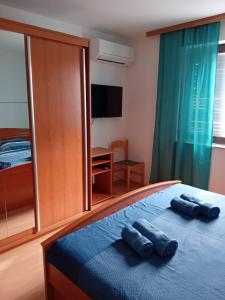 1 dormitorio con 1 cama con 2 toallas azules en Maria´s Haus en Novigrad Istria