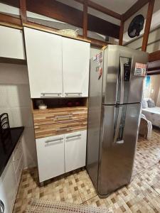 eine Küche mit einem Edelstahlkühlschrank und weißen Schränken in der Unterkunft Loft Maior Aconchegante in Angra dos Reis