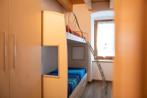 a bunk bed in a small room with a window at Casa Cerí in Bagolino