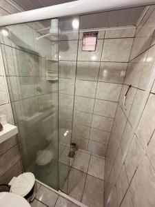 ein Badezimmer mit Glasdusche und Toilette in der Unterkunft Loft Maior Aconchegante in Angra dos Reis