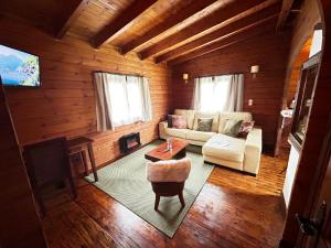 uma sala de estar com um sofá, uma mesa e uma televisão em Hotel Rural Casa de Campo em Soto de Cangas