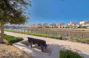a park bench sitting next to a body of water at Twin house in El Alamein