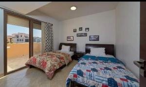 a bedroom with two beds and a balcony at Twin house in El Alamein