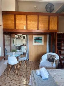 ein Wohnzimmer mit Bett und Tisch in einem winzigen Haus in der Unterkunft Loft Maior Aconchegante in Angra dos Reis