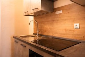 a kitchen with a sink and a wooden wall at Casa Cerí in Bagolino +37 photos
