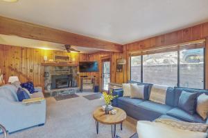 a living room with a blue couch and a fireplace at Shaver Village Chalet in Shaver Lake Heights