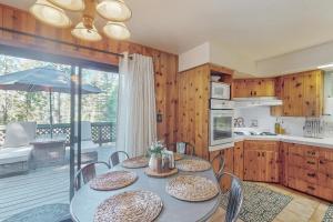 a dining room with a table and chairs and a kitchen at Shaver Village Chalet in Shaver Lake Heights