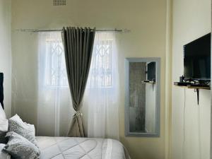 a bedroom with a bed and a window at LikeHome Guesthouse in Krugersdorp +3 photos