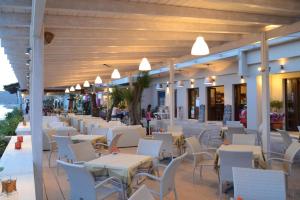 a restaurant with white tables and white chairs at Sappho Hotel in Skala Eresou
