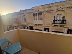 - Balcón con vistas a un edificio en Sir Patrick's rooms & hostel, en Għajn il-Kbira
