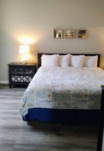 a bedroom with a bed and a table with a lamp at Pacific Plaza Resort in Oceano