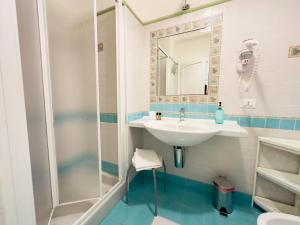 La salle de bains est pourvue d'un lavabo et d'une douche. dans l'établissement ELLE Monolocale - Sperlonga 50 mt dalla spiaggia con parcheggio, à Sperlonga