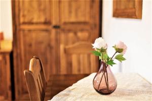 wazon z kwiatami na stole w obiekcie Gościniec Horb w Wetlinie