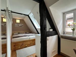 a small attic bedroom with a bed and a window at Wohnen auf der historischen Stadtmauer im Herzen von Detmold in Detmold
