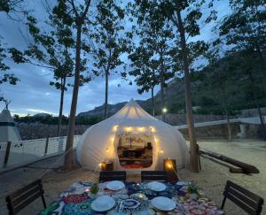una grande tenda con un tavolo di fronte ad essa di Camping la escalada a Gandía