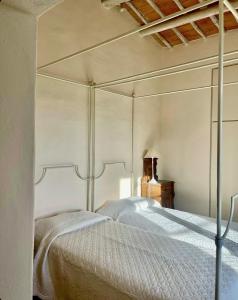 a bedroom with a four poster bed with white sheets at PodereVicoBasso Siena in Siena +21 photos