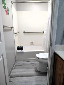 a bathroom with a toilet and a bath tub at Pacific Plaza Resort in Oceano