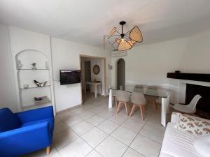 a living room with a blue couch and a table at Maison à 400 M de la plage de Pampelonne in Saint-Tropez