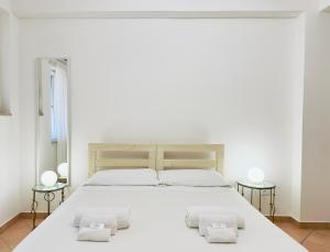 a bedroom with a large white bed with two side tables at ELLE Monolocale - Sperlonga 50 mt dalla spiaggia con parcheggio in Sperlonga