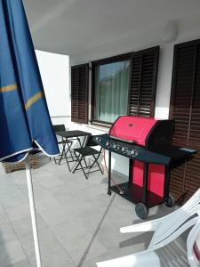 uma churrasqueira num quarto com cadeiras e um guarda-sol em Maria´s Haus em Novigrad Istria