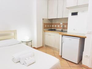- une cuisine blanche avec un lit et un évier dans l'établissement ELLE Monolocale - Sperlonga 50 mt dalla spiaggia con parcheggio, à Sperlonga