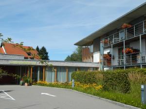 ein Gebäude mit einem Parkplatz davor in der Unterkunft Landhotel Allgäuer Hof in Wolfegg