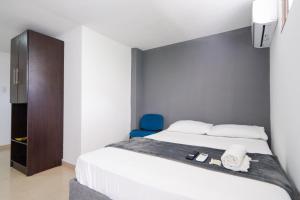 1 dormitorio con 1 cama y 1 silla azul en Hotel Imperial House, en Barranquilla