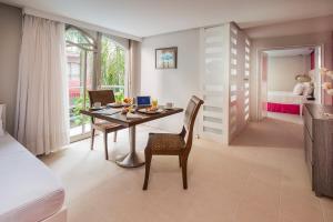 Zimmer mit einem Tisch und Stühlen sowie einem Schlafzimmer in der Unterkunft Country International Hotel in Barranquilla