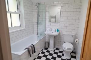 a bathroom with a sink and a toilet and a bath tub at Charlestown cottage, Woodburner, Gardens & Parking in Charlestown