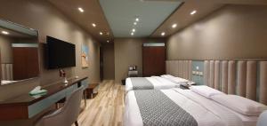 a hotel room with two beds and a television at Grand Bayan Hotel & Apt at Nile Plaza in Cairo