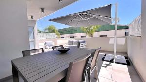 a black table with chairs and an umbrella on a balcony at Panorama Beach - Albatros Apartment in Torrox Costa