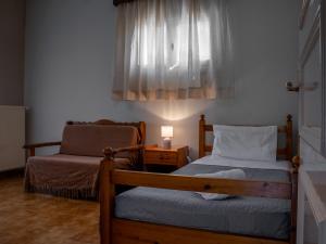 Un dormitorio con dos camas y una lámpara y una ventana. en Xenia's House, en Kato Korakiana