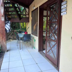an open door to a patio with a table and chairs at Casa Maresias Canto do mar - 50m da praia in Maresias