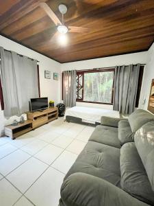 a living room with a couch and a bed at Casa Maresias Canto do mar - 50m da praia in Maresias