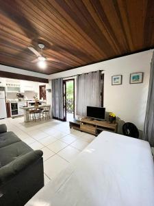 a living room with a couch and a tv at Casa Maresias Canto do mar - 50m da praia in Maresias
