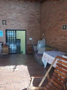 a patio with a table and chairs and a brick wall at Pousada Acolhedora in Ribeirão Preto