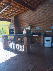 una cocina al aire libre con barra y taburetes en un patio en Pousada Acolhedora, en Ribeirão Preto