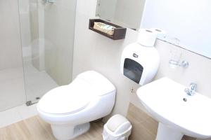 Baño blanco con aseo y lavamanos en Miskisol, en Piura