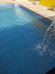 una gran piscina con agua azul. en Pousada Acolhedora, en Ribeirão Preto