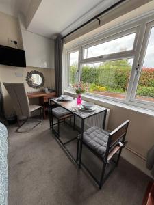 a living room with a table and chairs and a window at Greenlands Guest House in Highbridge