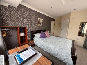 a small bedroom with a bed and a table at Greenlands Guest House in Highbridge