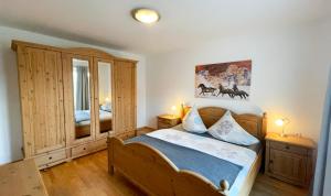 a bedroom with a wooden bed and a mirror at Apartments Alpenfrieden in Sankt Martin am Tennengebirge