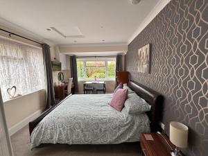 1 dormitorio con 1 cama con pared morada en Greenlands Guest House, en Highbridge