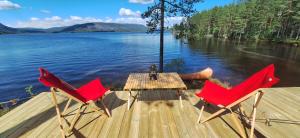 twee stoelen en een tafel op een steiger aan een meer bij Telemark Camping in Hauggrend