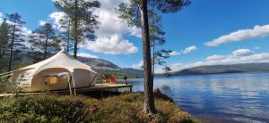 une tente blanche sur un quai à côté d'un lac dans l'établissement Telemark Camping, à Hauggrend