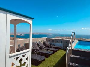 a balcony with chairs and a swimming pool at Twenty9th in Nadur